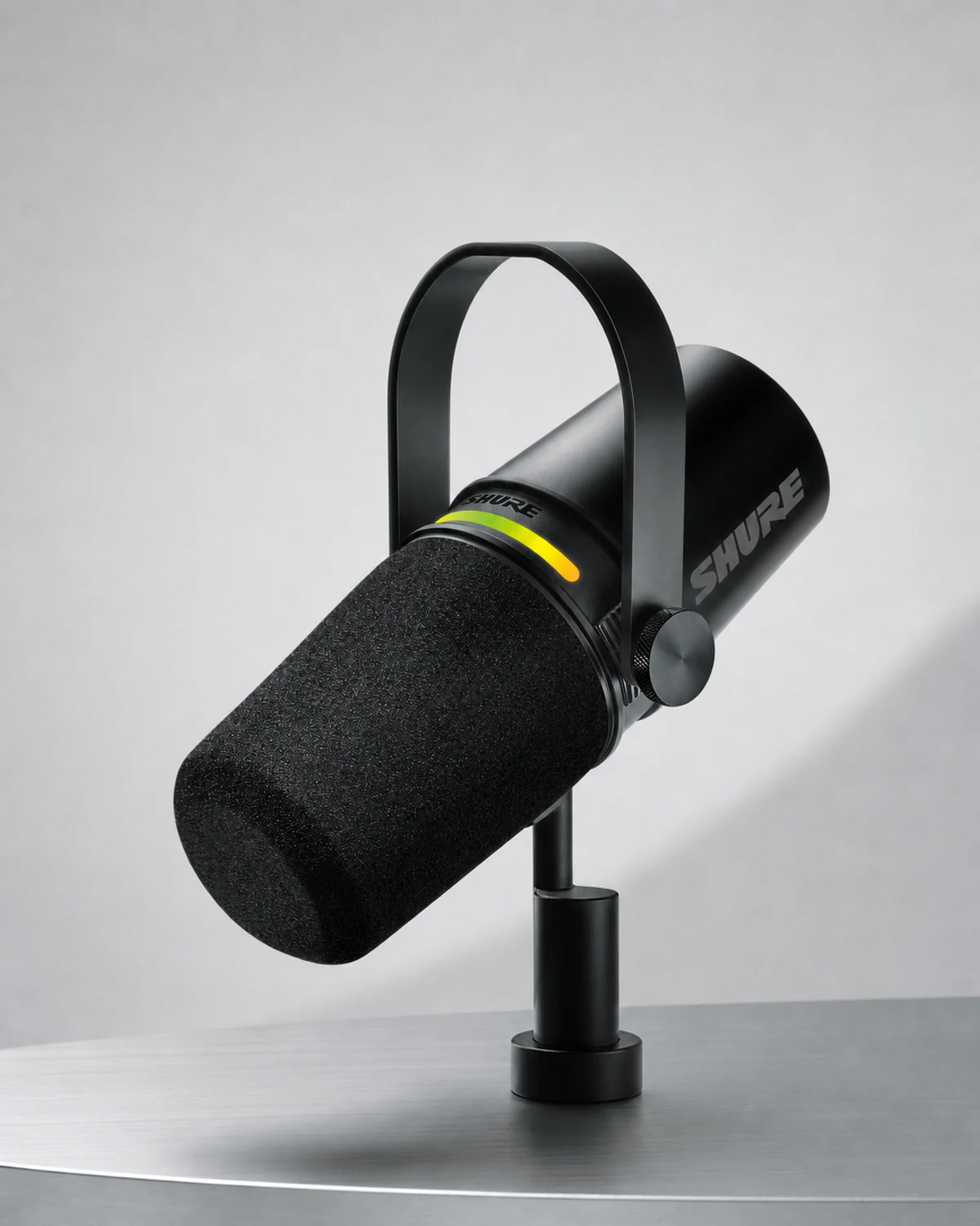 The same black Shure MV7+ microphone in a clean pale-gray ecommerce studio photograph.
